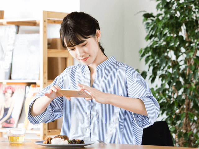 料理の写真を撮る女性