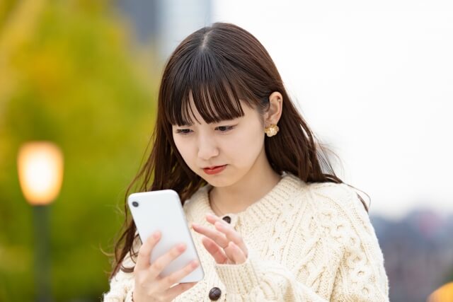 真剣な表情でスマホを見る女性