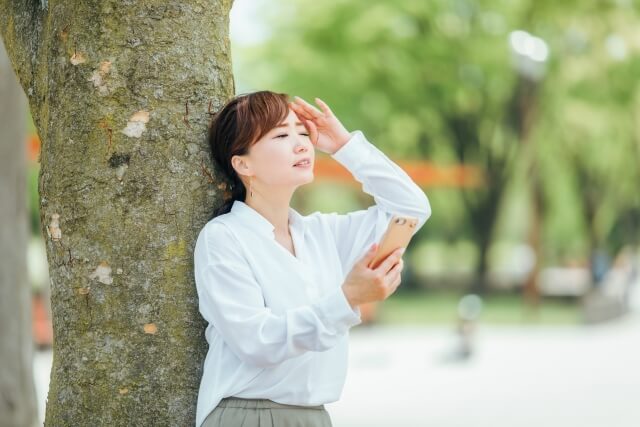 スマホ片手に頭を抱える女性