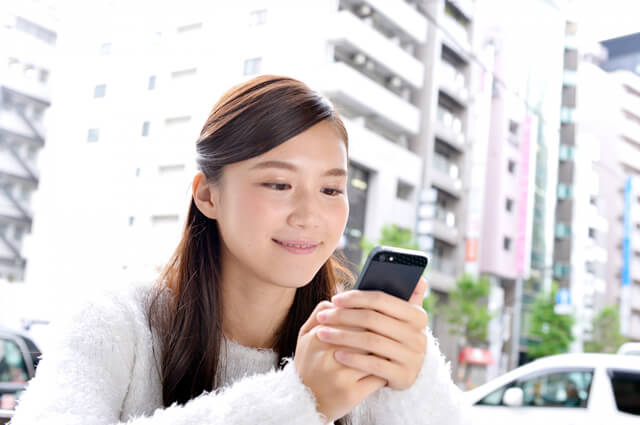 スマホを見て微笑む女性