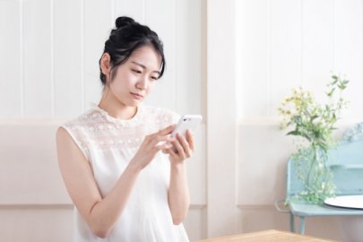 スマホを見て顔をしかめる女性