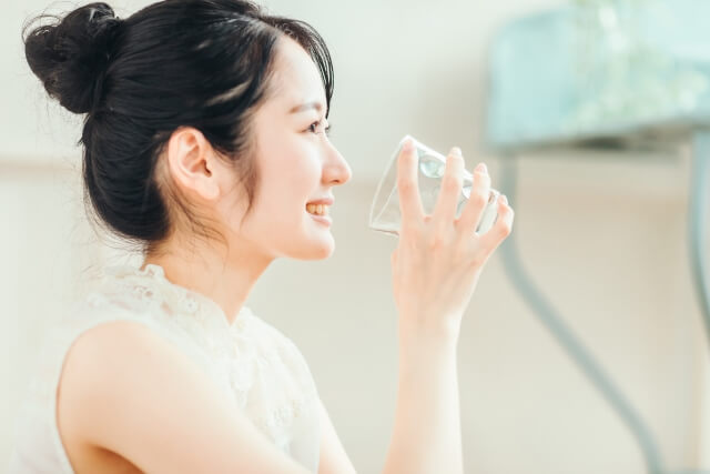 グラスで水を飲む女性